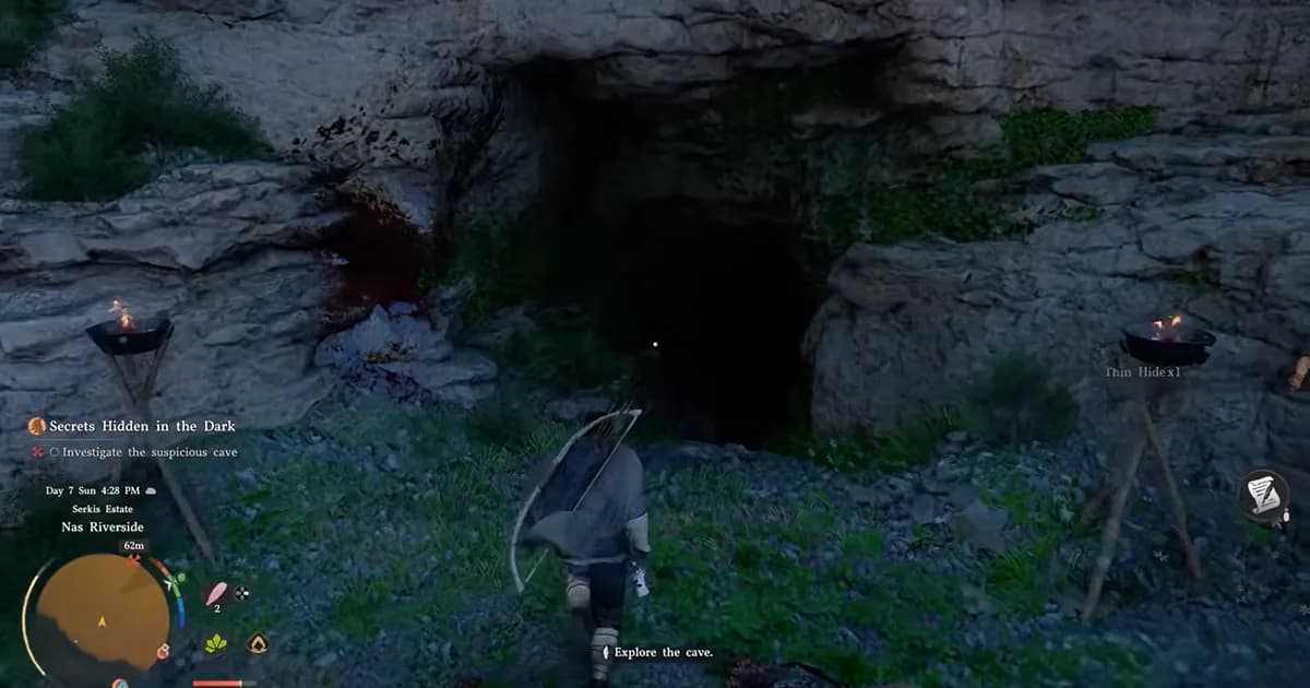 A warrior approaches the entrance to a dark cave surrounded by rocky cliffs and lit torches.